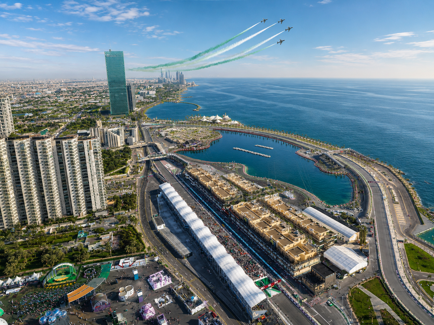 Aerial daytime view of the Jeddah Corniche F1 circuit with a jet flyover trailing green smoke