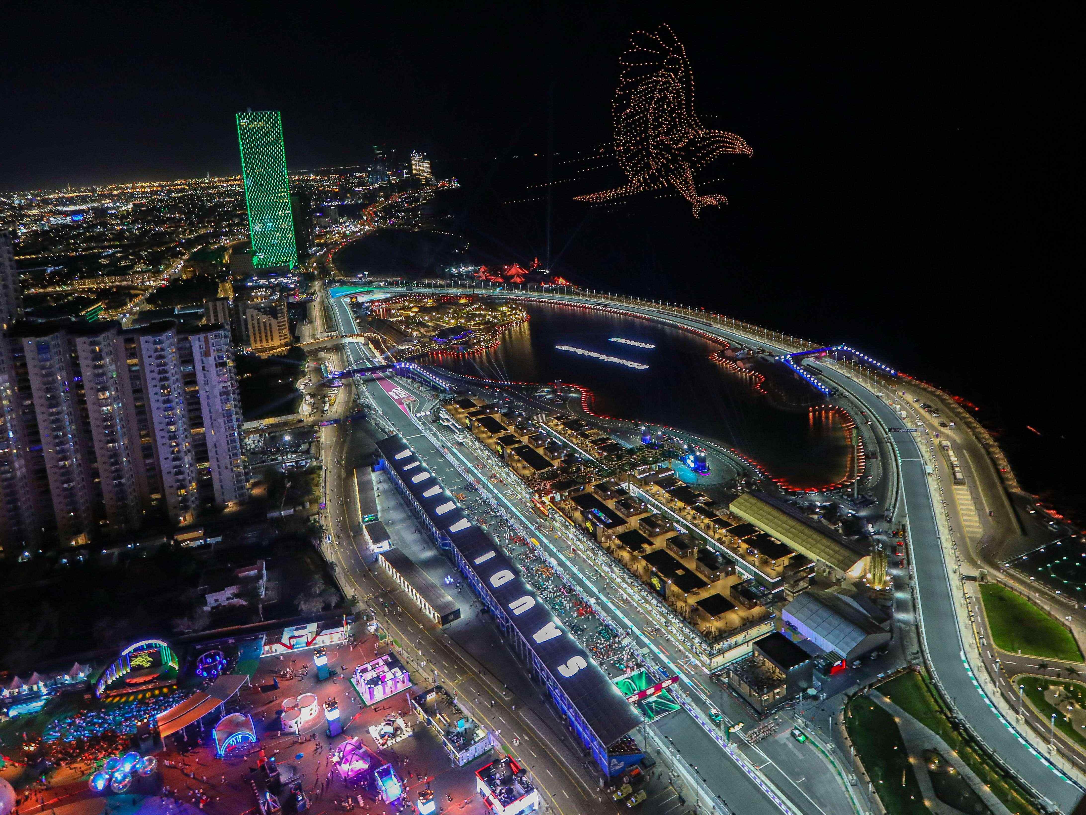 Aerial view of the illuminated Jeddah F1 circuit at night with a drone show